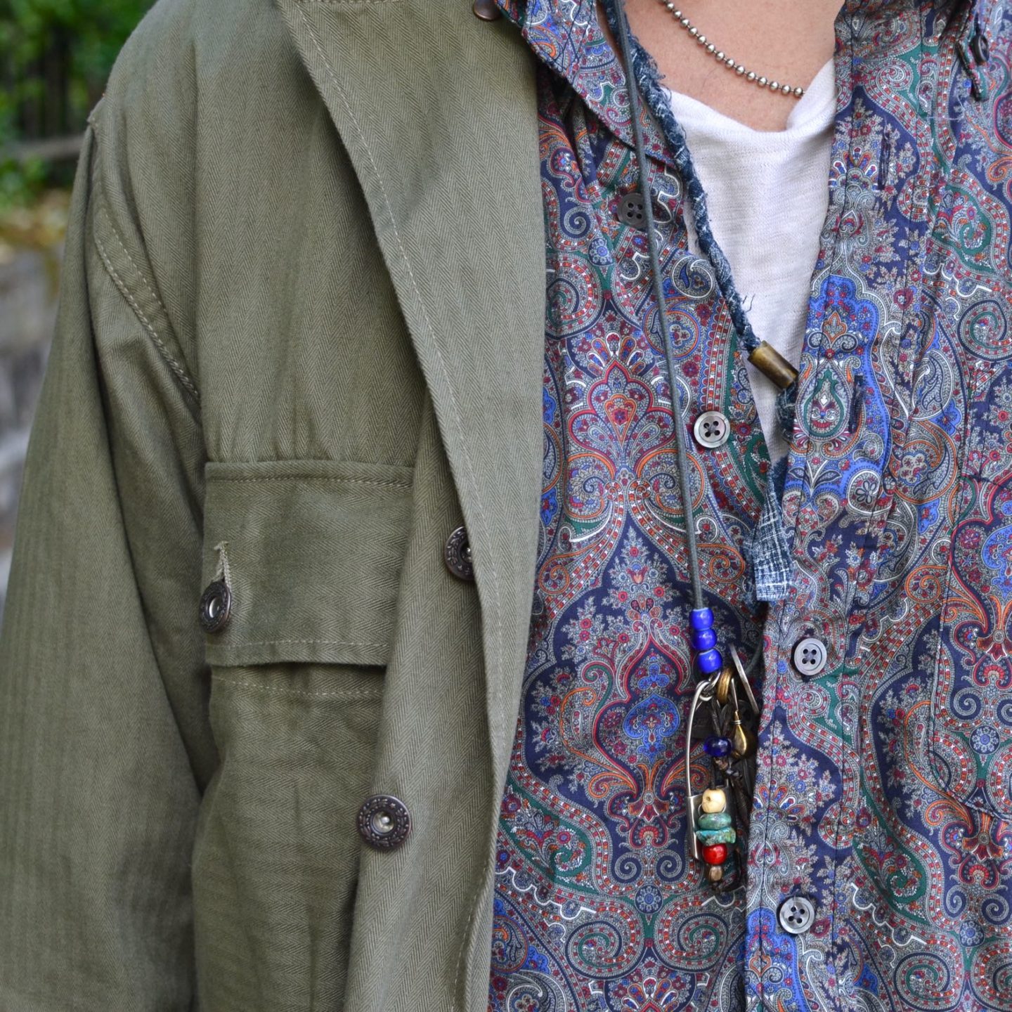 chemise militaire Arashi denim portée aevc une chemise à motif paisley Engineered garments avec un collier homme bijoux argent street heritage shop