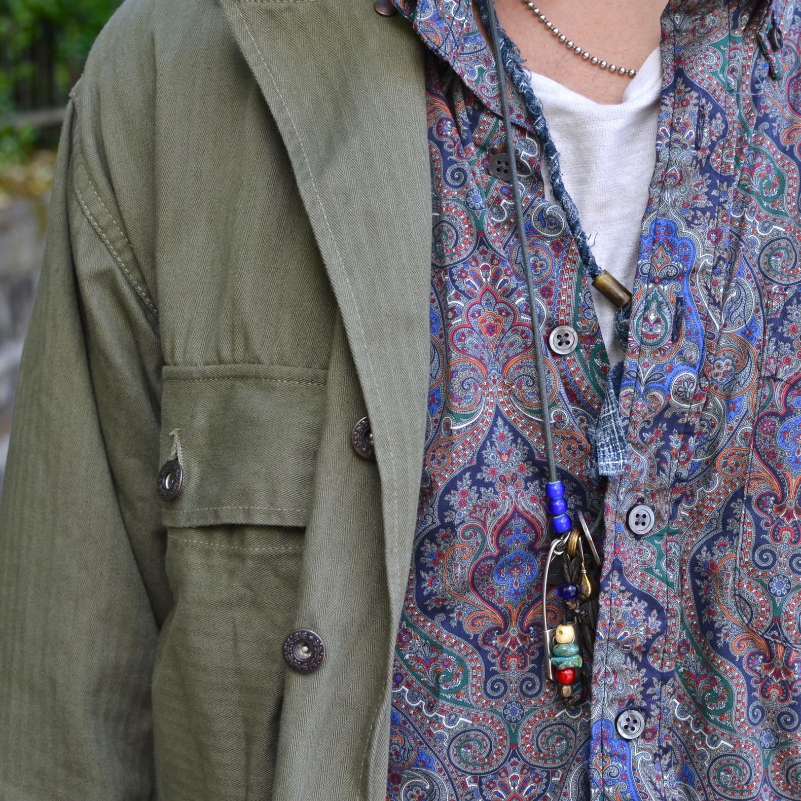 chemise militaire Arashi denim portée aevc une chemise à motif paisley Engineered garments avec un collier homme bijoux argent street heritage shop