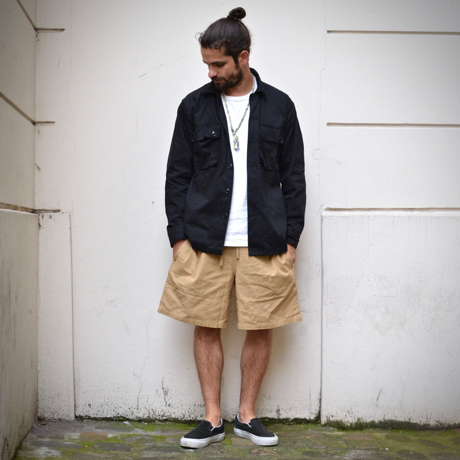look homme avec chemise noire militaire et short large thinking mu