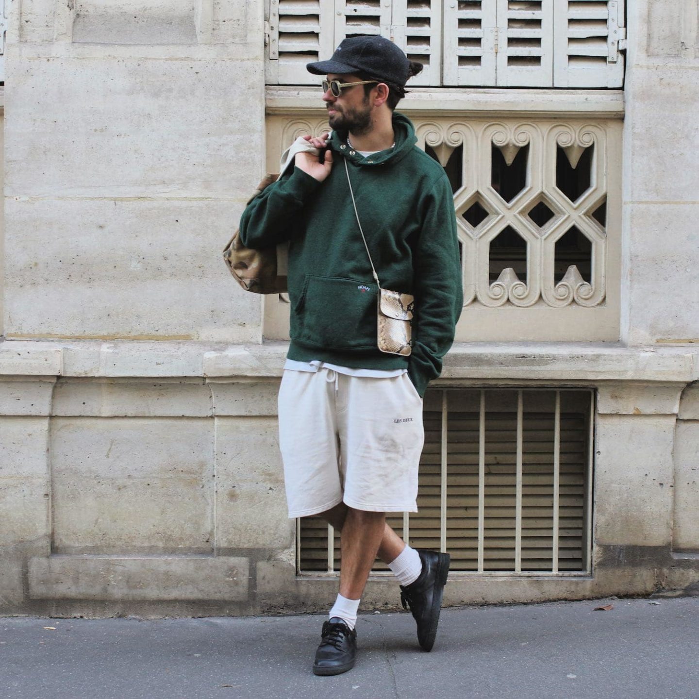 look homme streetwear chic avec casquette en laine et hoodie snap green noah avec pochette en cuir style python laperruque et lunettes marbin supreme