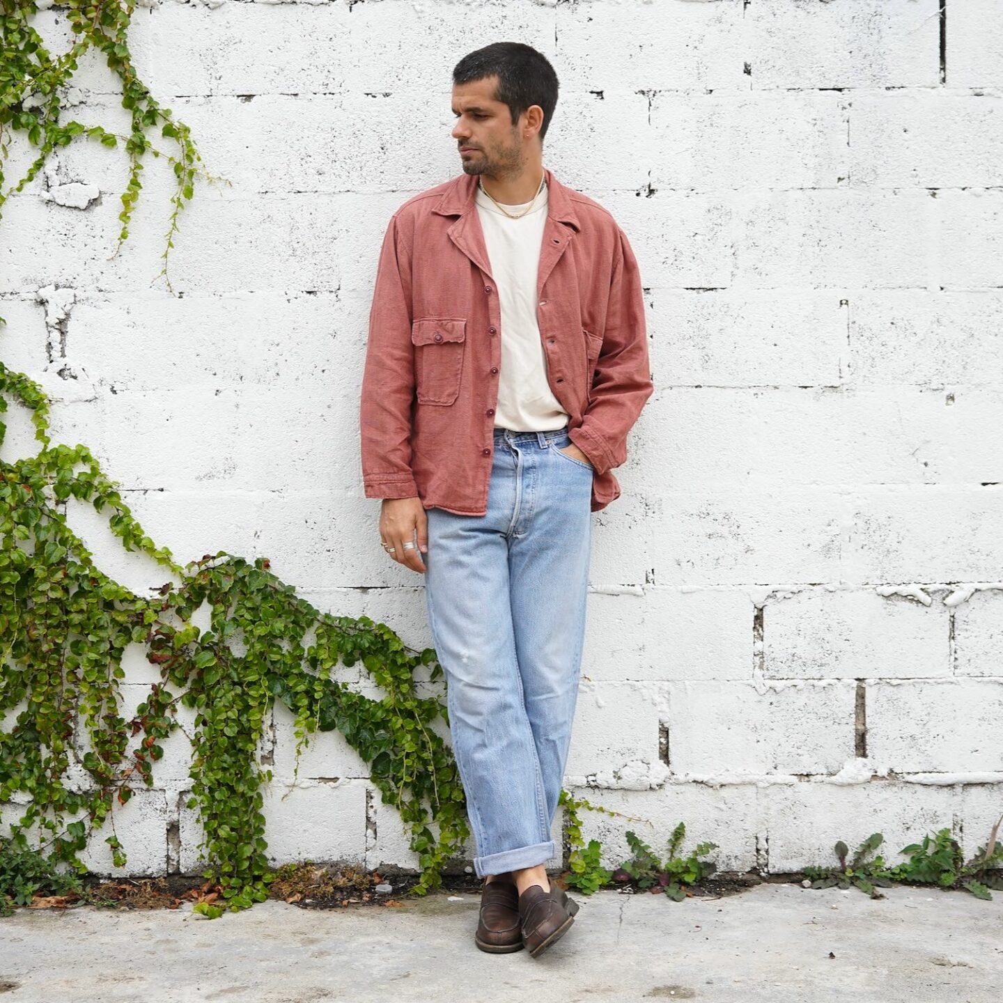 look homme avec un jean levi's 501 vintage, une chemise militaire type oG107 en lin rose et des mocassins marrons