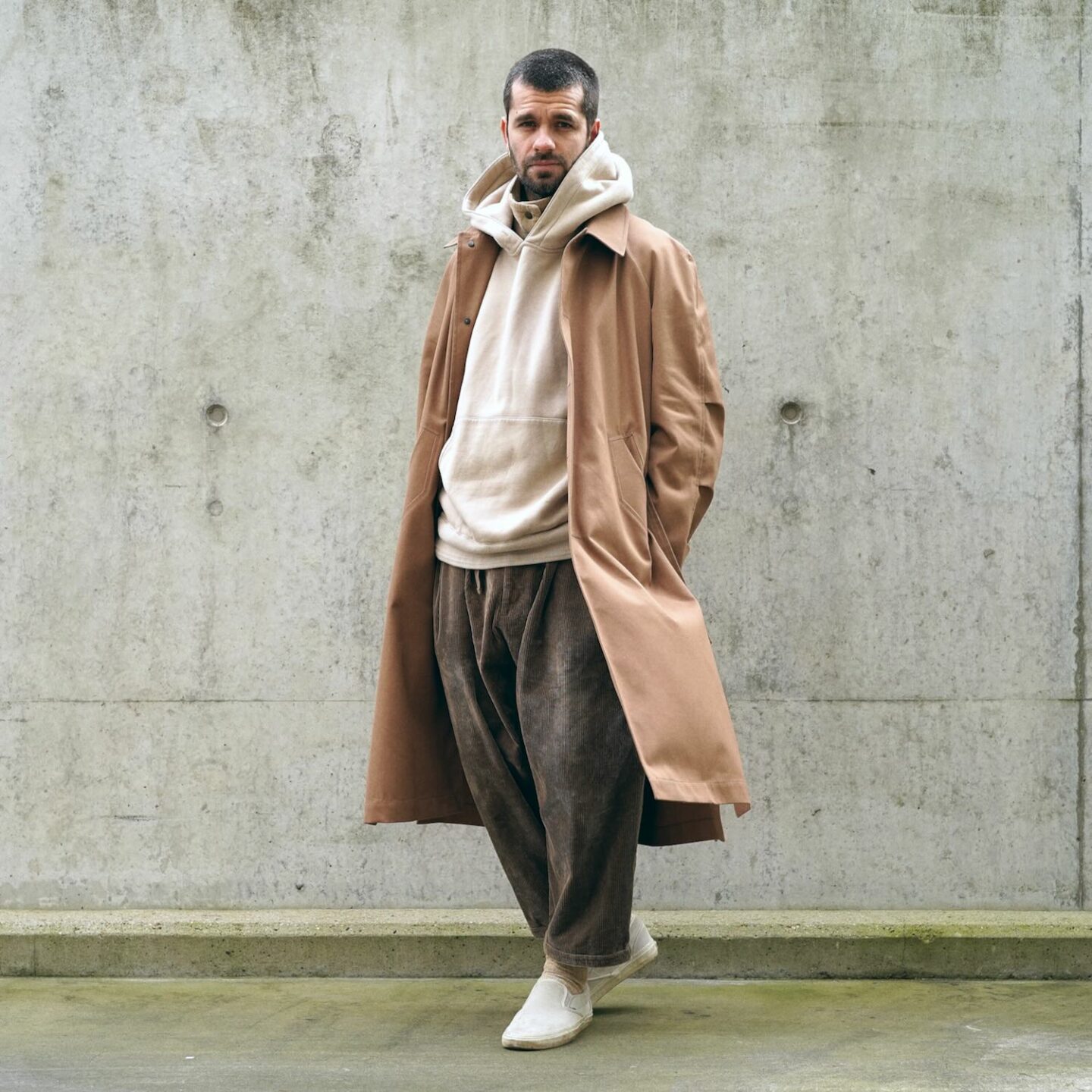 tenue homme avec un hoodie Kuro, un pantalon baggy en velours sillage et des vans slipon, le tout avec le trench 120 coltesse, dans un style oversize