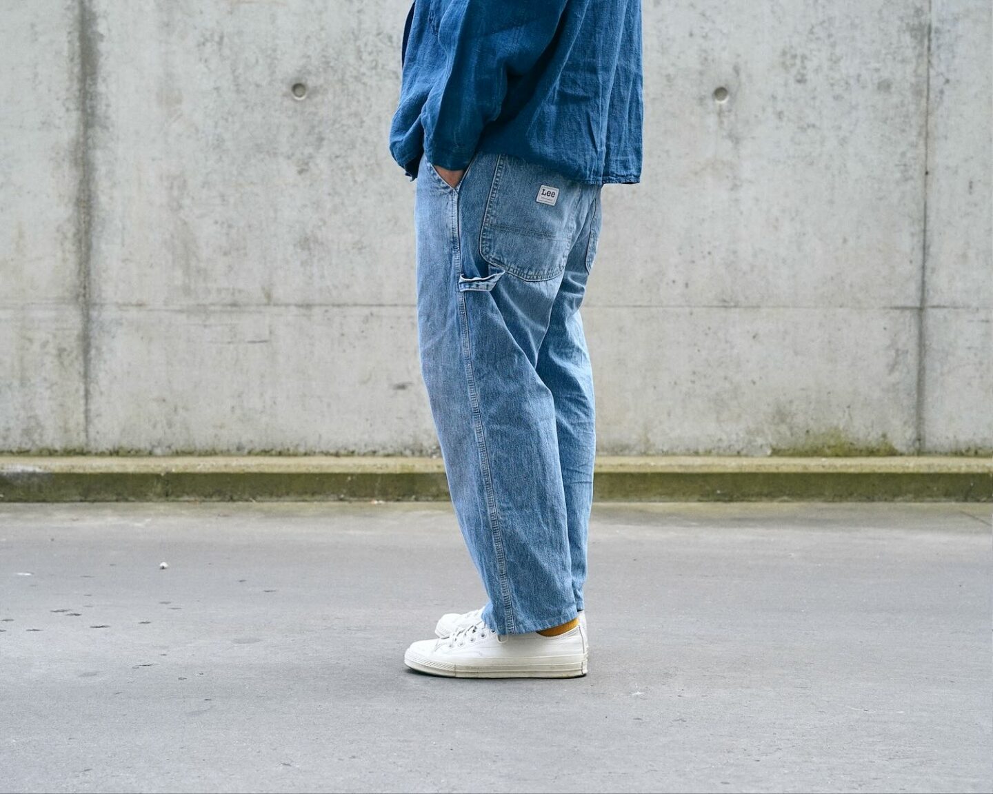 pantalon de charpentier dit carpenter pants en denim coton chanvre d ela marque Lee porté avec des converse ct70 low