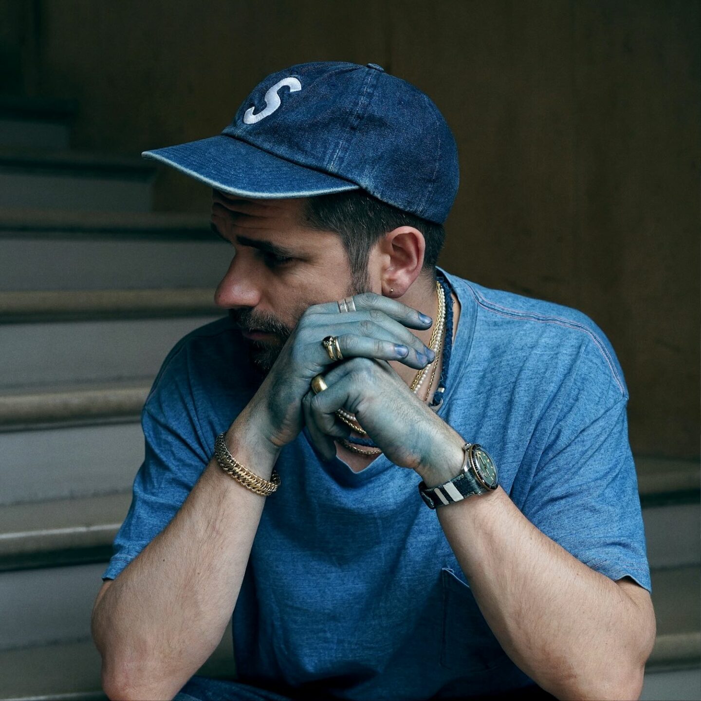 portrait du styliste Boras avec les mains bleues indigo et des bijoux