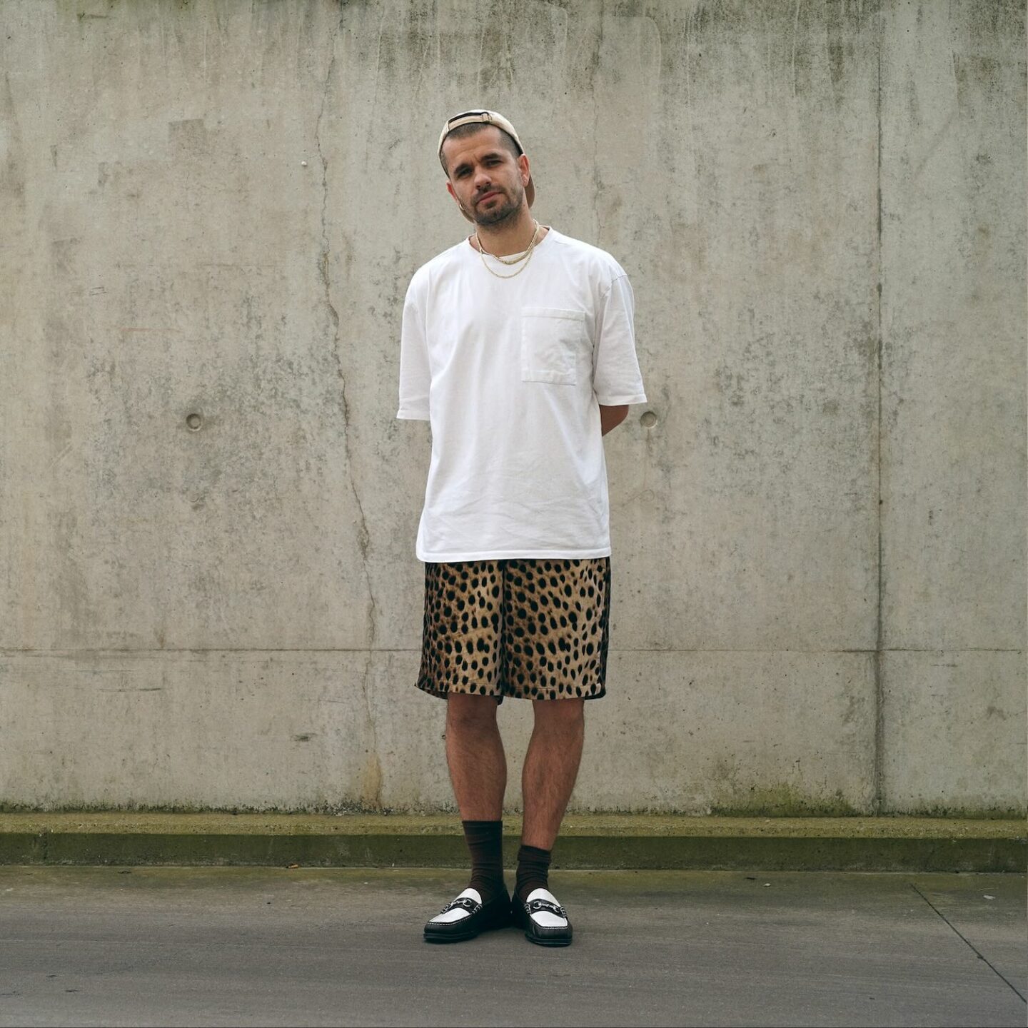 look avec un short imprimé guépard (léopard) porté avec un t-shirt blanc oversize et des mocassins bicolores GH Bass