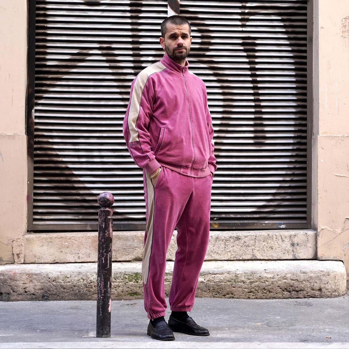 tenue homme avec un jogging en velours rose de la marque Supreme et des mocassins noirs