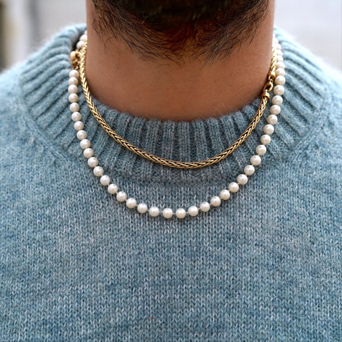 collier de perles naturelles vintage porté par un homme et chaine en or à maille palmier