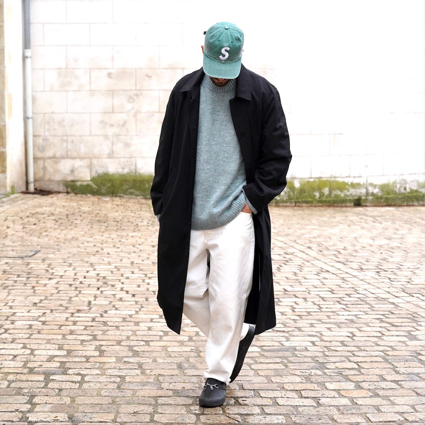 tenue homme avec un jean blanc taille haute de la marque Borali, un trench noir Coltesse, un pull en laine d'alpaga COS et des vans slipon