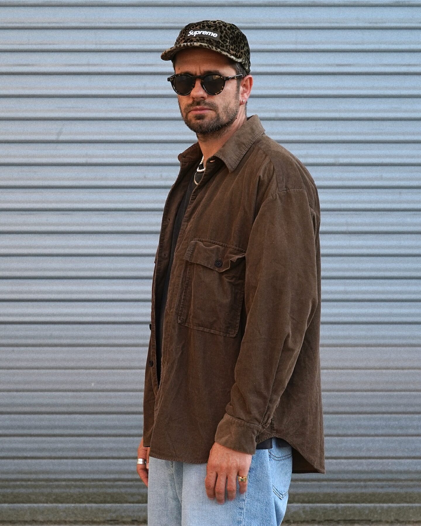 surchemise en velours marron de la marque Evan Kinori modèle big shirt, porté avec une casquette supreme léopard et des lunettes arpenteur
