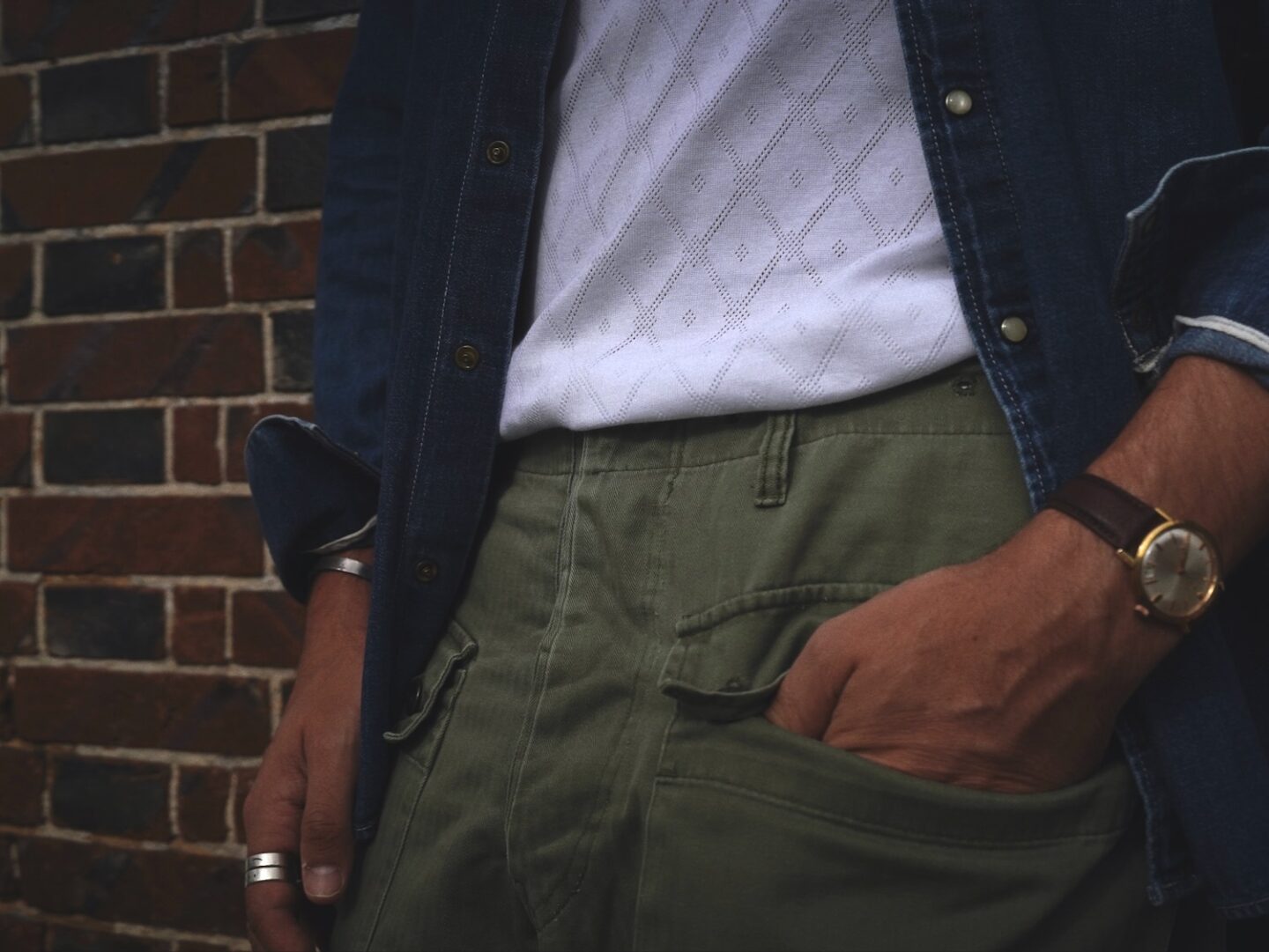 débardeur en maille ajourée porté avec un pantalon militaire et une chemise en denim type western